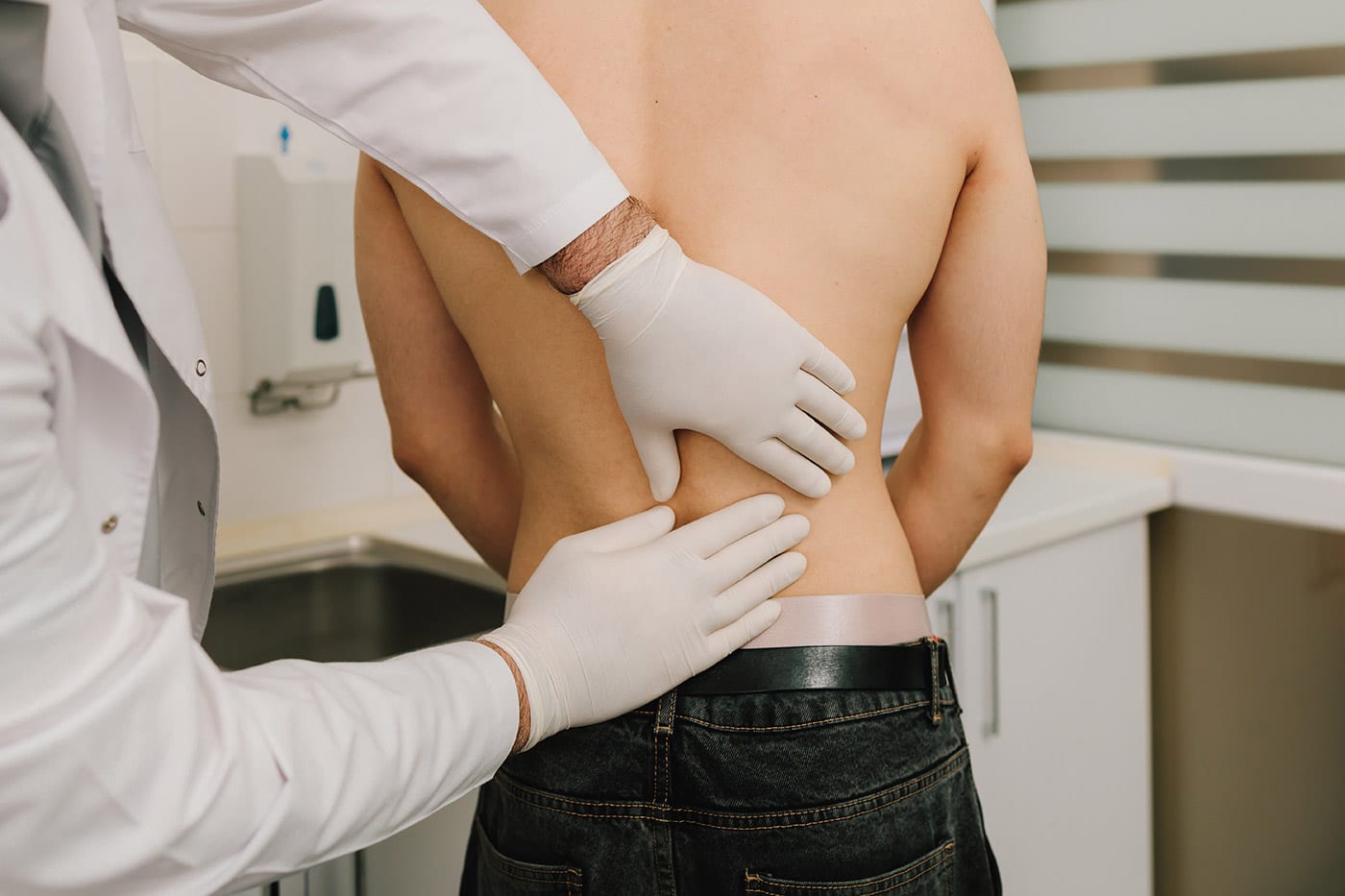medical exam doctor checking patient s back pain 2026 09 25 02 05 11 utc